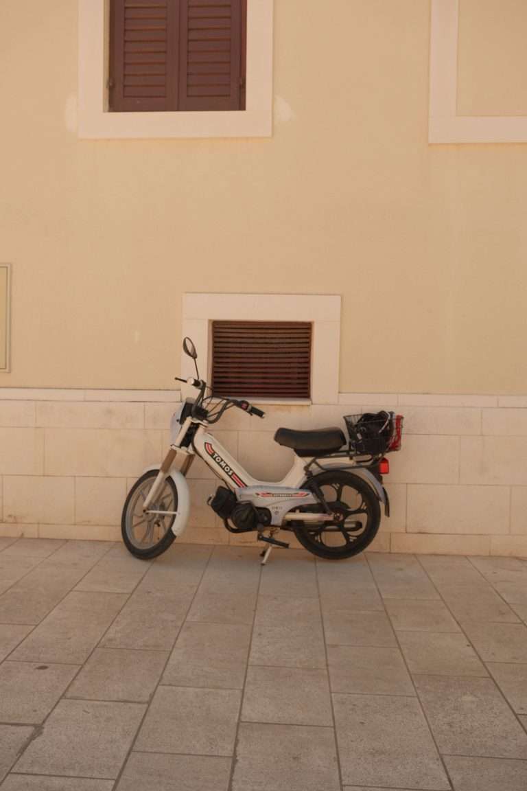 Cyclomoteur vintage contre mur beige à l'extérieur